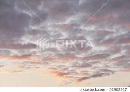 Copy space of altocumulus clouds in a moody sky at twilight. Scenic panoramic of a dramatic cloudscape and thunderous background at sunrise or sunset. Climate of gloomy dark weather at dawn outdoors Copy space of altocumulus clouds in a moody sky at twilight. Scenic panoramic of a dramatic cloudscape and thunderous background at sunrise or sunset. Climate of gloomy dark weather at dawn outdoors 92902317