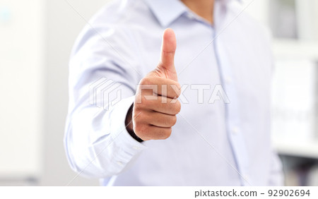 Thumbs up for celebrating success and good work, hand of business man, manager or entrepreneur showing hand gesture. Closeup sign and positive symbol of approval, agreement and trust on fingers 92902694