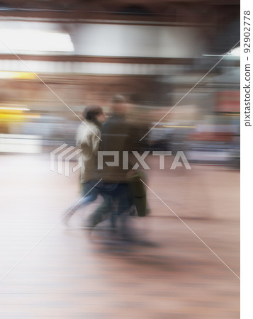 A busy crowd of travellers arriving and walking together in a street in the city. Group tourists in defocused movement downtown. People travelling in a blurry motion with copy space and bokeh. A busy crowd of travellers arriving and walking together in a street in the city. Group tourists in defocused movement downtown. People travelling in a blurry motion with copy space and bokeh. 92902778