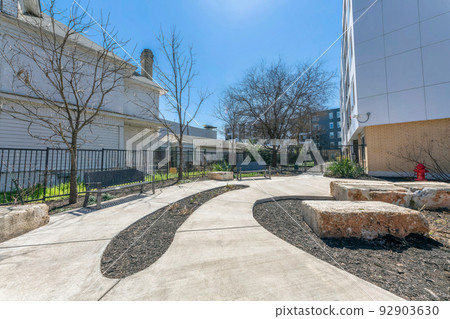 Pathway with benches and large concrete blocks on the side near the buildings at San Antonio, Texas 92903630