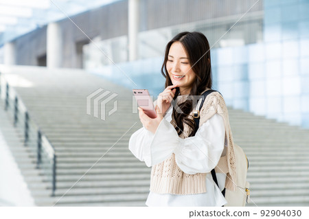 College girl looking at a smartphone College girl looking at a smartphone 92904030