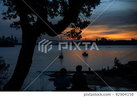 Sunset couple silhouette and sydney bay 92904156