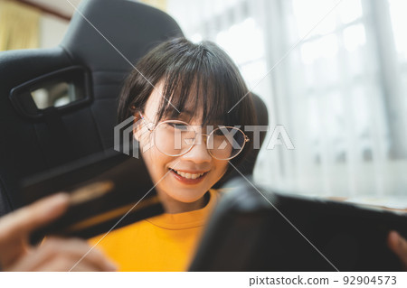 Young adult asian play game at home. Young adult asian play game at home. 92904573