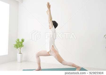 在家做瑜伽高弓步姿勢的高級女性 92905904