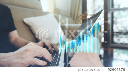 Man hand typing laptop keyboard with bullish financial stock graph profit increase 92906876