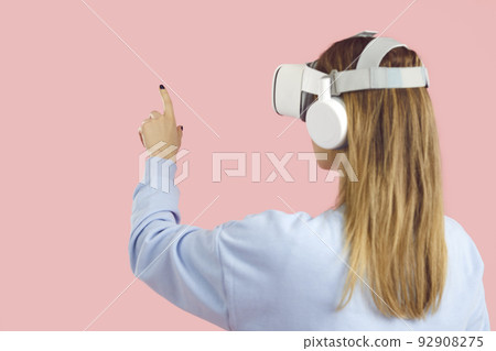 Woman in VR glasses touch air with hands Woman in VR glasses touch air with hands 92908275