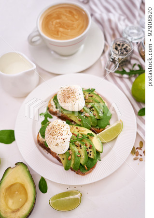 Freshly made poached egg and Avocado toasts on light grey background 92908620