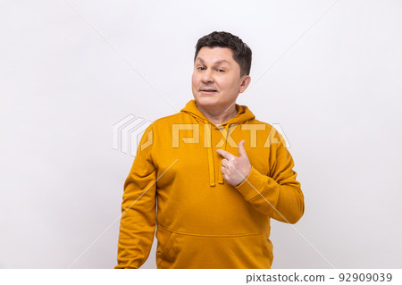 Proud handsome man pointing fingers on himself and looking at camera with pride, extremely confident, wearing urban style hoodie. Indoor studio shot isolated on white background. Proud handsome man pointing fingers on himself and looking at camera with pride, extremely confident, wearing urban style hoodie. Indoor studio shot isolated on white background. 92909039