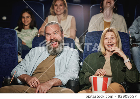Group of people spending weekend at cinema watching funny comedy movie, selective focus shot 92909557