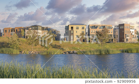 Panorama Puffy clouds at sunset Oquirrh Lake at the front of residential complex buildings at Da 92909956