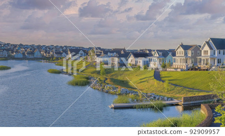 Panorama Puffy clouds at sunset Oquirrh Lake at Daybreak residential community with concrete pav 92909957