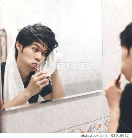 Adult asian man toothbrush in front of mirror toothache and tried. Adult asian man toothbrush in front of mirror toothache and tried. 92910682
