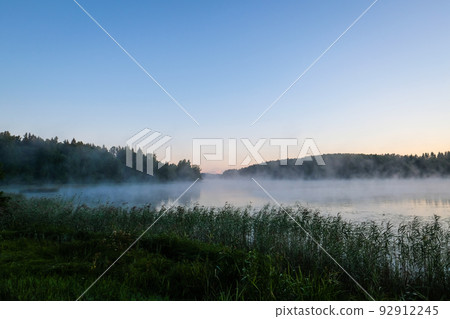 Very beautiful sunrise in summer over a foggy lake. Early morning in summer in nature. Defocused Very beautiful sunrise in summer over a foggy lake. Early morning in summer in nature. Defocused 92912245
