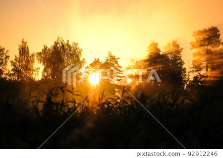 Very beautiful sunrise in summer over a foggy lake. Early morning in summer in nature. Defocused Very beautiful sunrise in summer over a foggy lake. Early morning in summer in nature. Defocused 92912246
