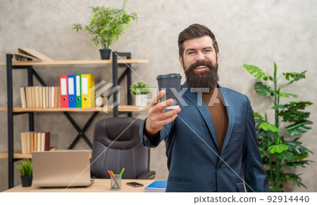 cheerful bearded business man drinking takeaway coffee in the office with copy space, to go cheerful bearded business man drinking takeaway coffee in the office with copy space, to go 92914440