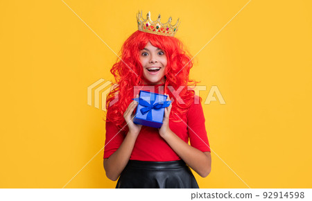 amazed child in diadem with present box on yellow background amazed child in diadem with present box on yellow background 92914598