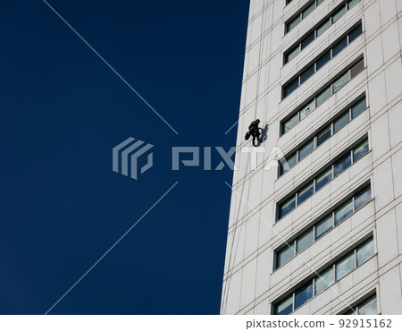 Industrial climber in helmet and uniform on height 92915162