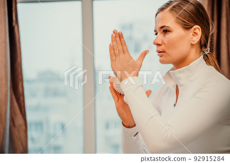 Athletic slim caucasian woman doing thigh self-massage with a massage ball indoors. Self-isolating massage Athletic slim caucasian woman doing thigh self-massage with a massage ball indoors. Self-isolating massage 92915284