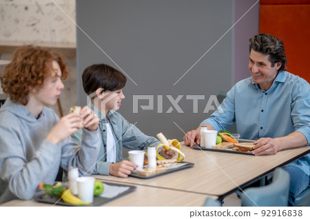 Boys having lunch in a school canteen Boys having lunch in a school canteen 92916838