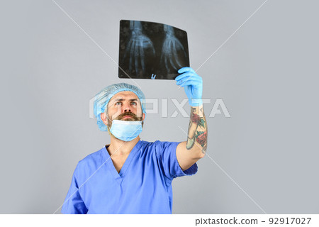 Surgery operation and medical concept. man look at roentgen. Radiologist hold xray. doctor examines radiographical snapshot. x-raying of hands. nurse checking x-ray film at hospital. health problems Surgery operation and medical concept. man look at roentgen. Radiologist hold xray. doctor examines radiographical snapshot. x-raying of hands. nurse checking x-ray film at hospital. health problems 92917027