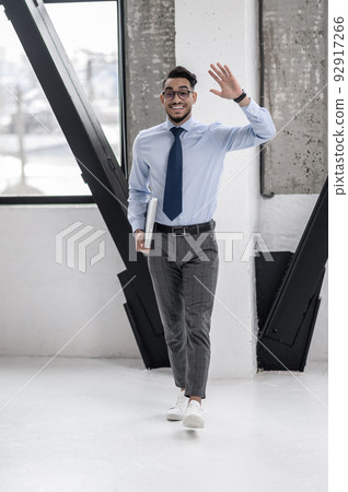Happy business man gesturing greeting walking towards camera Happy business man gesturing greeting walking towards camera 92917266