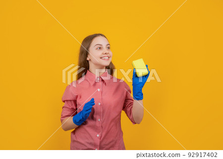 cheerful child in rubber gloves with sponge on yellow background 92917402