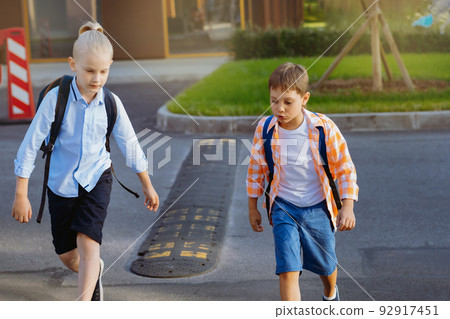 children walking to school crossing road in illegal place. Begining of academic year children walking to school crossing road in illegal place. Begining of academic year 92917451