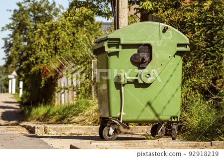 Green recycling container on the street 92918219
