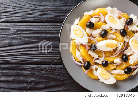 Remojon salad of oranges, boiled salted fish, eggs and red onions close-up in a plate. Horizontal top view 92918349