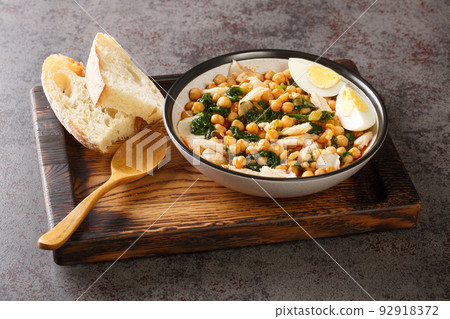 Spanish food for Easter Potaje de vigilia Chickpea stew with spinach and cod close-up in a bowl on the wooden tray. Horizontal Spanish food for Easter Potaje de vigilia Chickpea stew with spinach and cod close-up in a bowl on the wooden tray. Horizontal 92918372