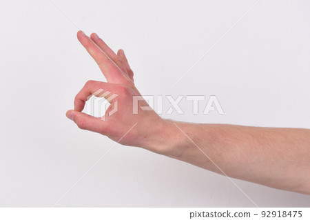 Male hand shows okay sign. Gesture expresses approval. 92918475