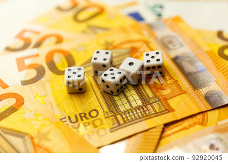 White Gaming dice and money on dark table. 92920045