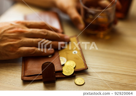 Fired man countsing his last money to drink expensive alcohol. 92920064