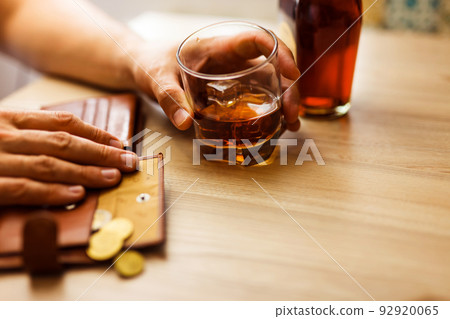 Fired man countsing his last money to drink expensive alcohol. Fired man countsing his last money to drink expensive alcohol. 92920065