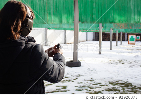 A man shoots a target in a dash. Winter sports, entertainment, firearms, gun. 92920373