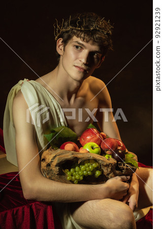 Creative remake of painting boy with a basket of fruit. Young handsome man over dark vintage background. Italian baroque style, art, creativity, vintage 92921239