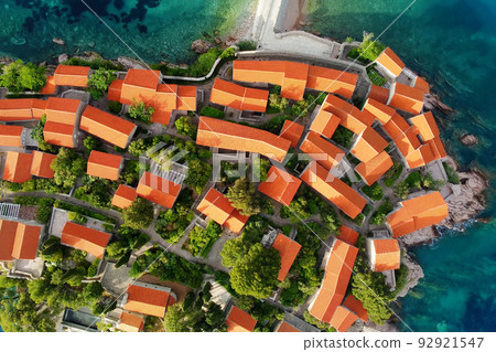 Amazing sunset aerial top drone view of Sveti Stefan island with historical town. Top down view of picturesque little island in Adriatic Sea located in Montenegro. 92921547