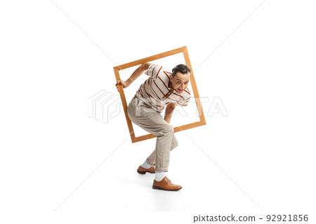 Portrait of stylish man appearing from picture frame isolated over white background. Retro style Portrait of stylish man appearing from picture frame isolated over white background. Retro style 92921856