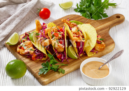 Bang Bang Shrimp Tacos on wood board, top view 92922129