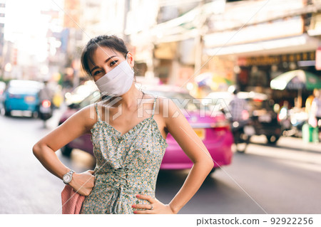 Happy asian adult woman tan skin wear mask on face for new normal. Happy asian adult woman tan skin wear mask on face for new normal. 92922256