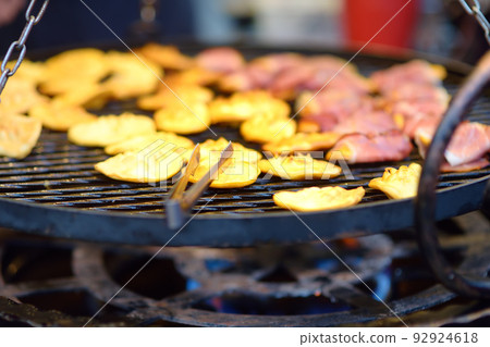 Traditional Poland street food oscypek is a grilled cheese of salted sheep milk with different ingredients as bacon or jams. Cooking of oscypek on Christmas market in Krakow. 92924618
