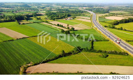 Aerial european countryside landscape at sunset. Drone point view of agricultural fields, roads, copses. Aerial european countryside landscape at sunset. Drone point view of agricultural fields, roads, copses. 92924625
