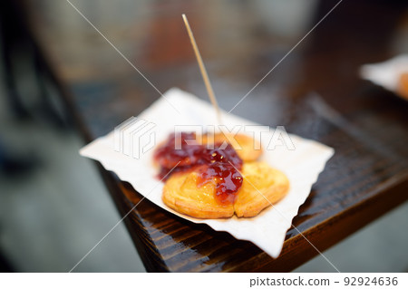 A portion of oscypek on Christmas market in Krakow. Oscypki - traditional Poland street food is a grilled cheese of salted sheep milk with different ingredients as bacon or jams. 92924636