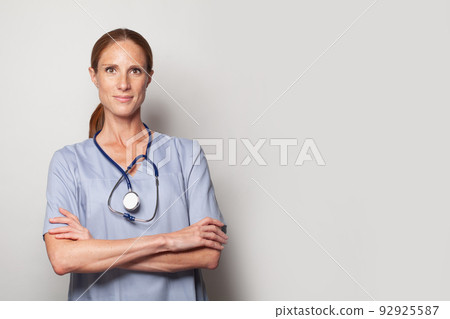 Medical physician doctor standing with crossed arms on white background. 92925587