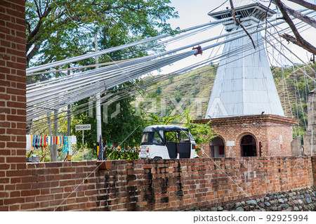 Traditional motorcycle at the entrance of the historical Bridge of the West a a suspension bridge declared Colombian National Monument built in 1887 over the Cauca River 92925994