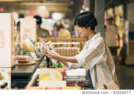 Woman buying souvenirs while traveling 92926077