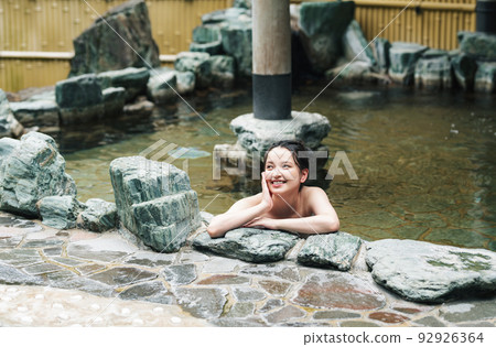 A young woman relaxing in a hot spring 92926364