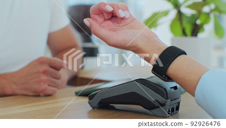 Woman hand with smartwatch using terminal for payment, non-cash transaction, side view. Non-cash payment concept. Pos-terminal on table on black background. 92926476