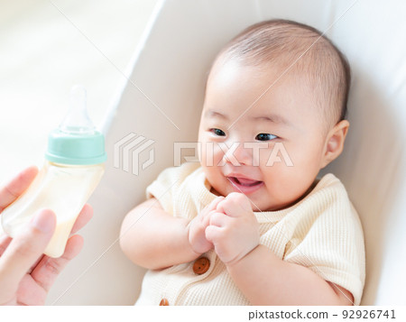 A baby with a happy expression looking at milk A baby with a happy expression looking at milk 92926741