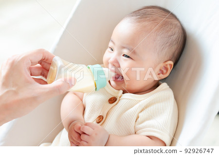 baby drinking milk deliciously 92926747
